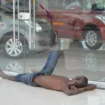 homeless person looking at cars